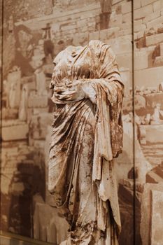 Headless marble statue in ruins at Delphi, Greece, showcasing classical art.