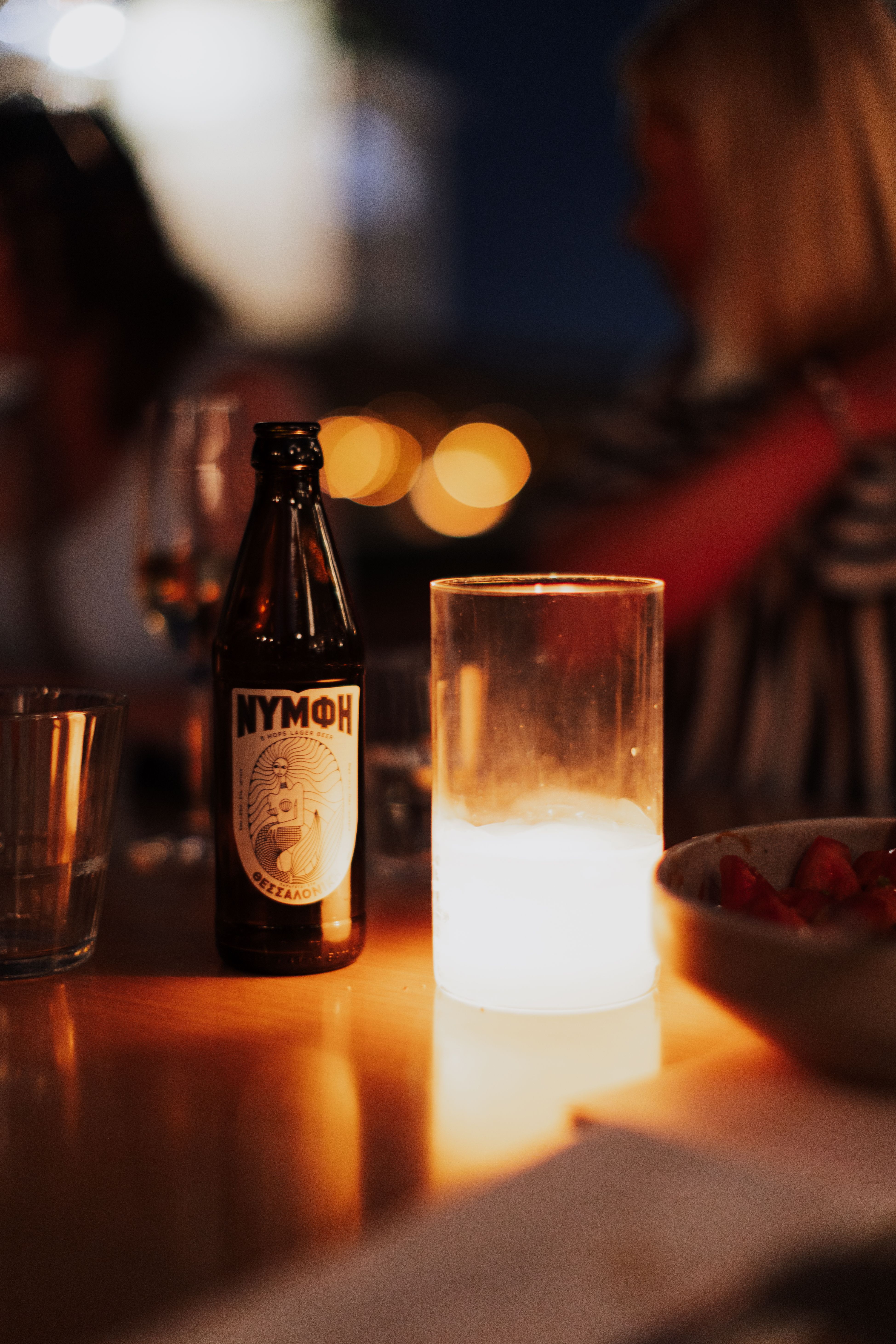 Candlelit dinner with drinks at a cozy outdoor setting in Athens, Greece.