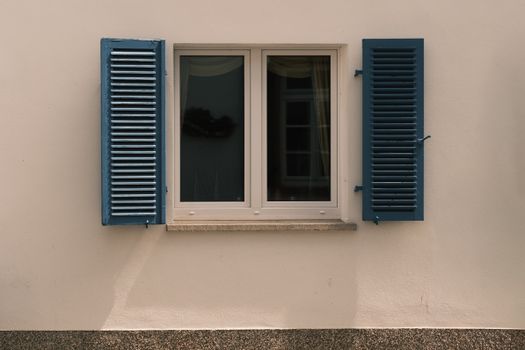 A classic window with blue shutters on a historic building in Rüdesheim, Germany.