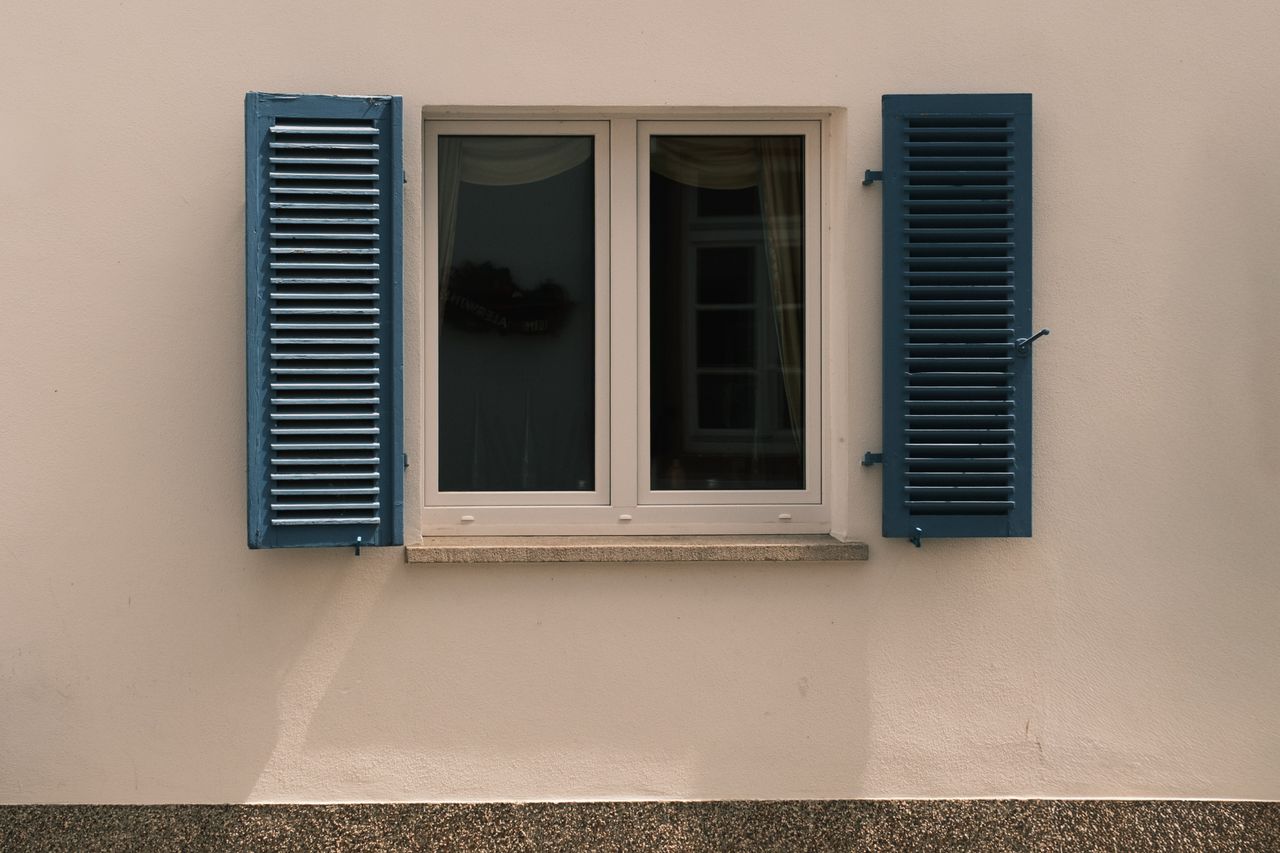 a classic window with blue shutters on a historic building in r deshei