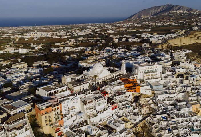 Aerial photograph showcasing the whitewashed buildings and beautiful landscapes of Fira, Santorini, Greece.