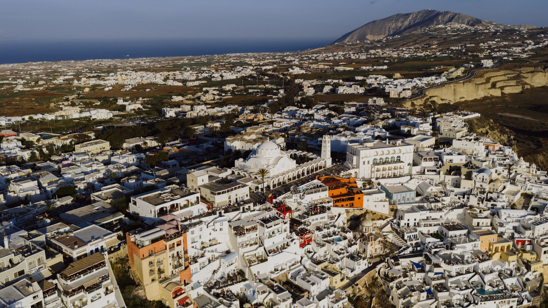 Aerial photograph showcasing the whitewashed buildings and beautiful landscapes of Fira, Santorini, Greece.