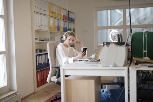 Woman In White Long Sleeve Shirt Holding A Mobile Phone