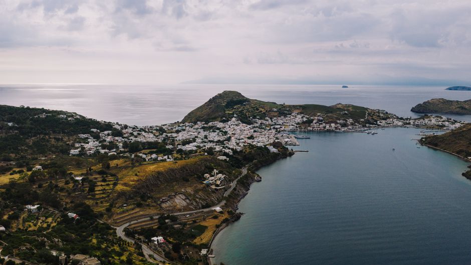 Amazing Helicopter Flight Over Santorini's Iconic Landscapes Review 2026 - Breathtaking aerial view of Patmos Island, Greece, showcasing its coastal beauty and charming architecture.