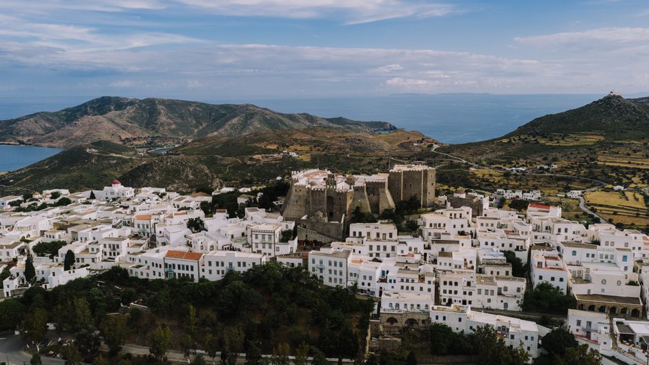 Amazing Helicopter Flight Over Santorini's Iconic Landscapes Review 2026 - A stunning aerial capture of Patmos, Greece, showcasing traditional white buildings and historical landmarks.