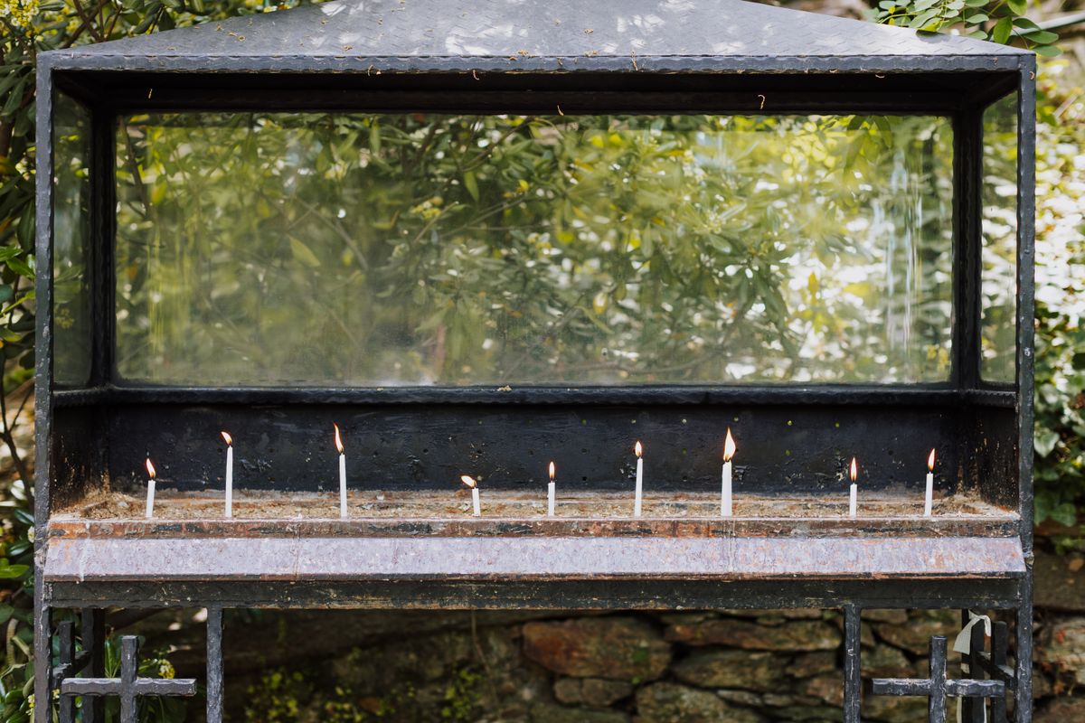 Vitrina metalica exterioara plina de lumanari aprinse