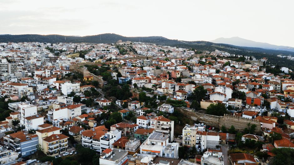 Breathtaking Point-to-Point Mykonos Transfer Service Review: The Most Luxurious Way to Travel in Greece Review 2026 - Aerial view of the vibrant cityscape of Thessaloniki, Greece with orange rooftops and hills in the background.