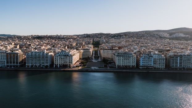 Aerial shot of Thessaloniki's waterfront showcasing urban architecture against serene waters.