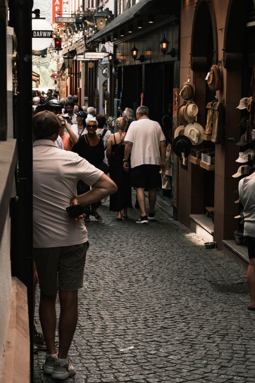 Free Explore a vibrant, cobblestone alley in Rüdesheim am Rhein, filled with tourists enjoying summer shopping and dining. Stock Photo