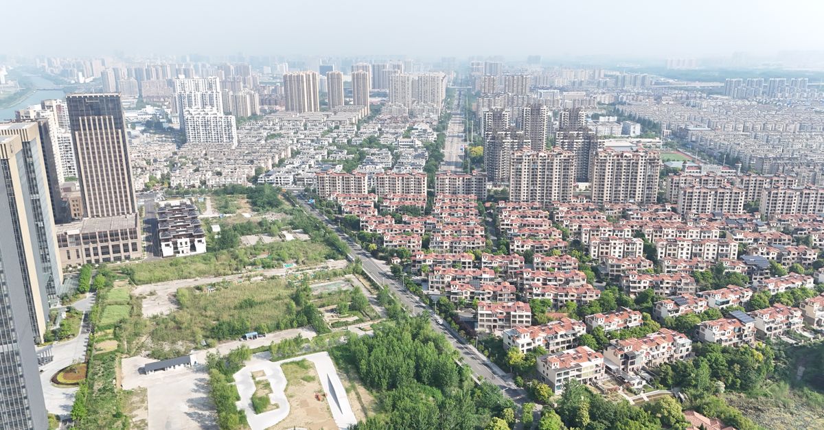 Aerial view of a bustling city with high-rise buildings and residential areas.
