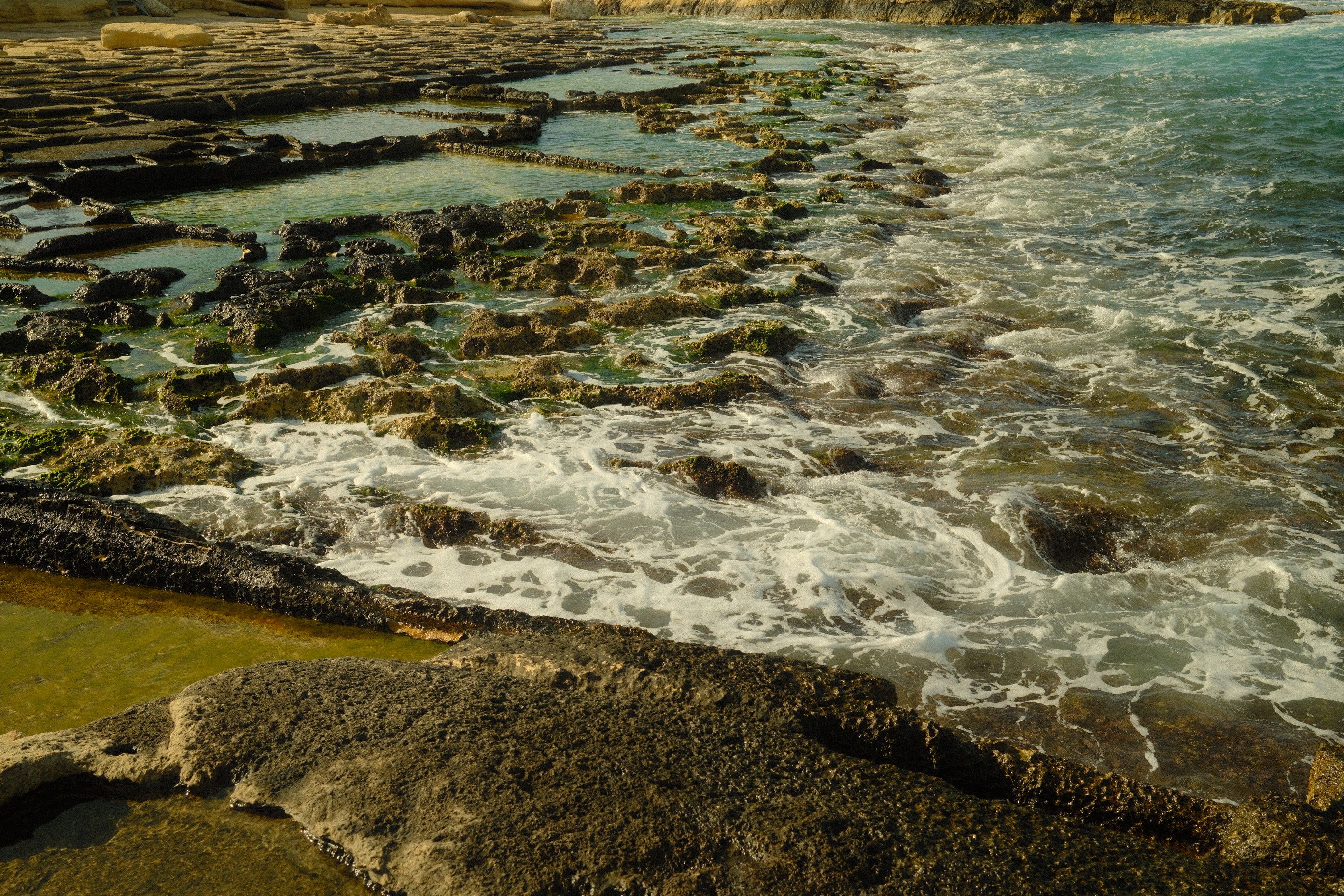 Waves crashing against the rocky coast of Malta on a windy day