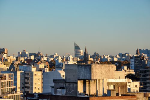 Free A vibrant view of Montevideo's skyline featuring modern and historic architecture under a sunset sky. Stock Photo