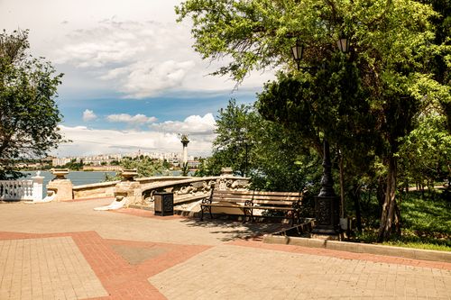 Free Tranquil park scenery in Sevastopol with benches, greenery, and distant city view. Stock Photo