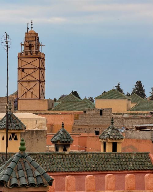 Free A panoramic view of a historic minaret and traditional rooftops in Marrakesh, Morocco. Stock Photo