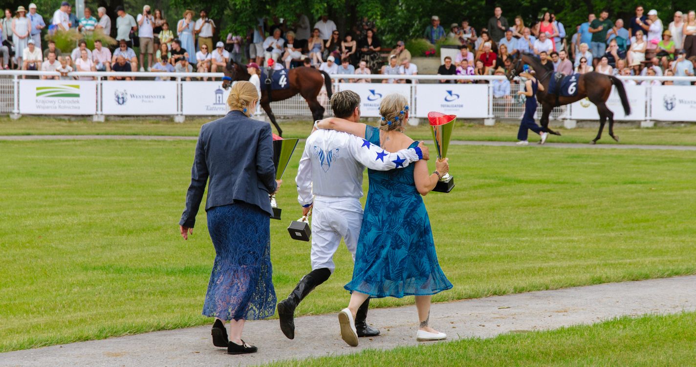 Jockey et public célébrant une victoire lors d'une réunion de courses hippiques en plein air
