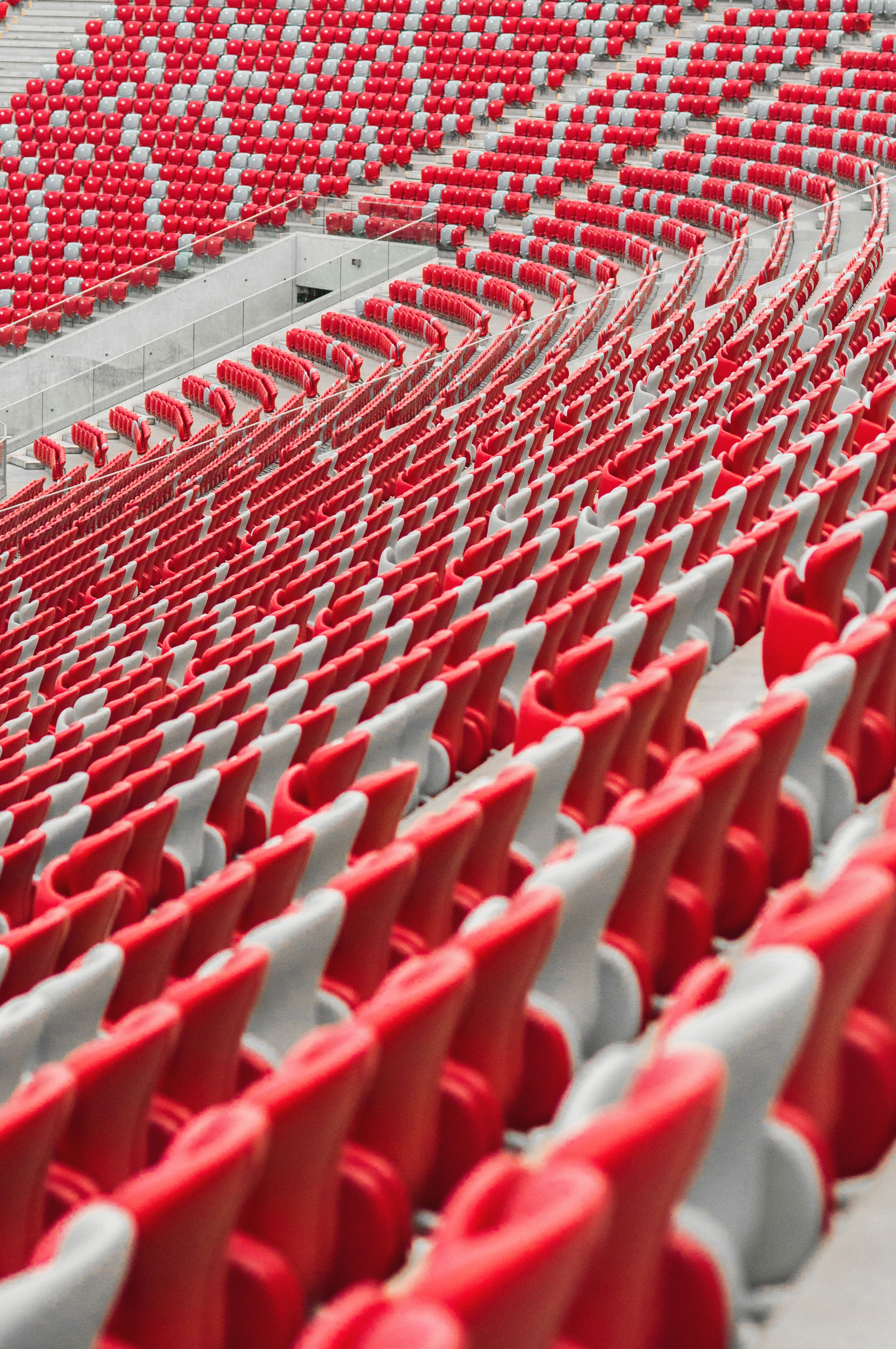 Empty stadium seats in red and white create a vivid geometric pattern.