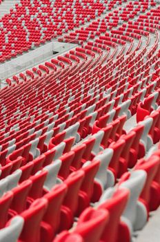Empty stadium seats in red and white create a vivid geometric pattern.