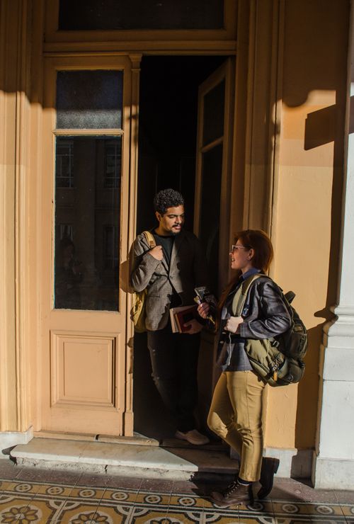Free Two students converse at a university door in Buenos Aires, Argentina. Stock Photo