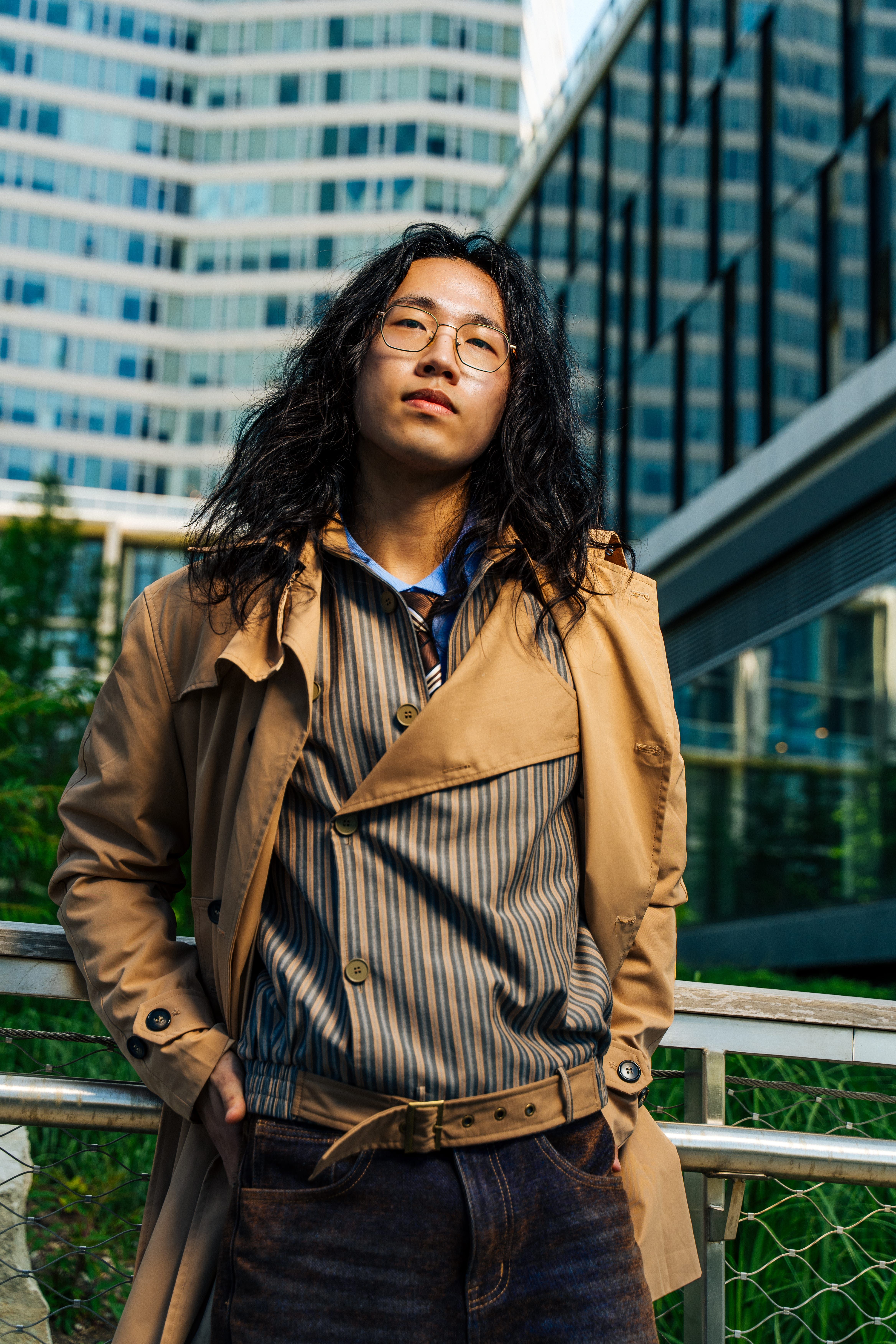 Confident adult posing stylishly with urban skyscrapers in the background.
