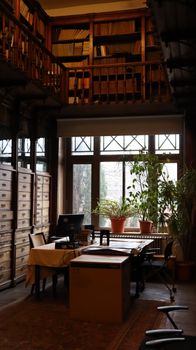 A cozy vintage library with wooden shelves and a window view in Istanbul, Türkiye.