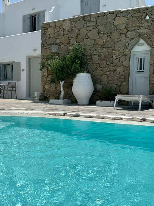 Free White villa with poolside, Greek architecture under a bright summer sun. Stock Photo