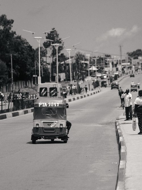 Free A bustling street in Jos, Nigeria featuring a tricycle and pedestrians during the day. Stock Photo