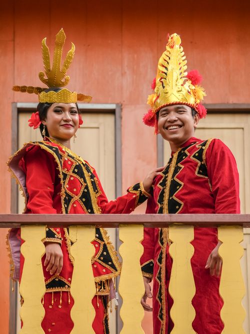 Free Couple in traditional costumes smiling on a balcony, showcasing cultural heritage. Stock Photo