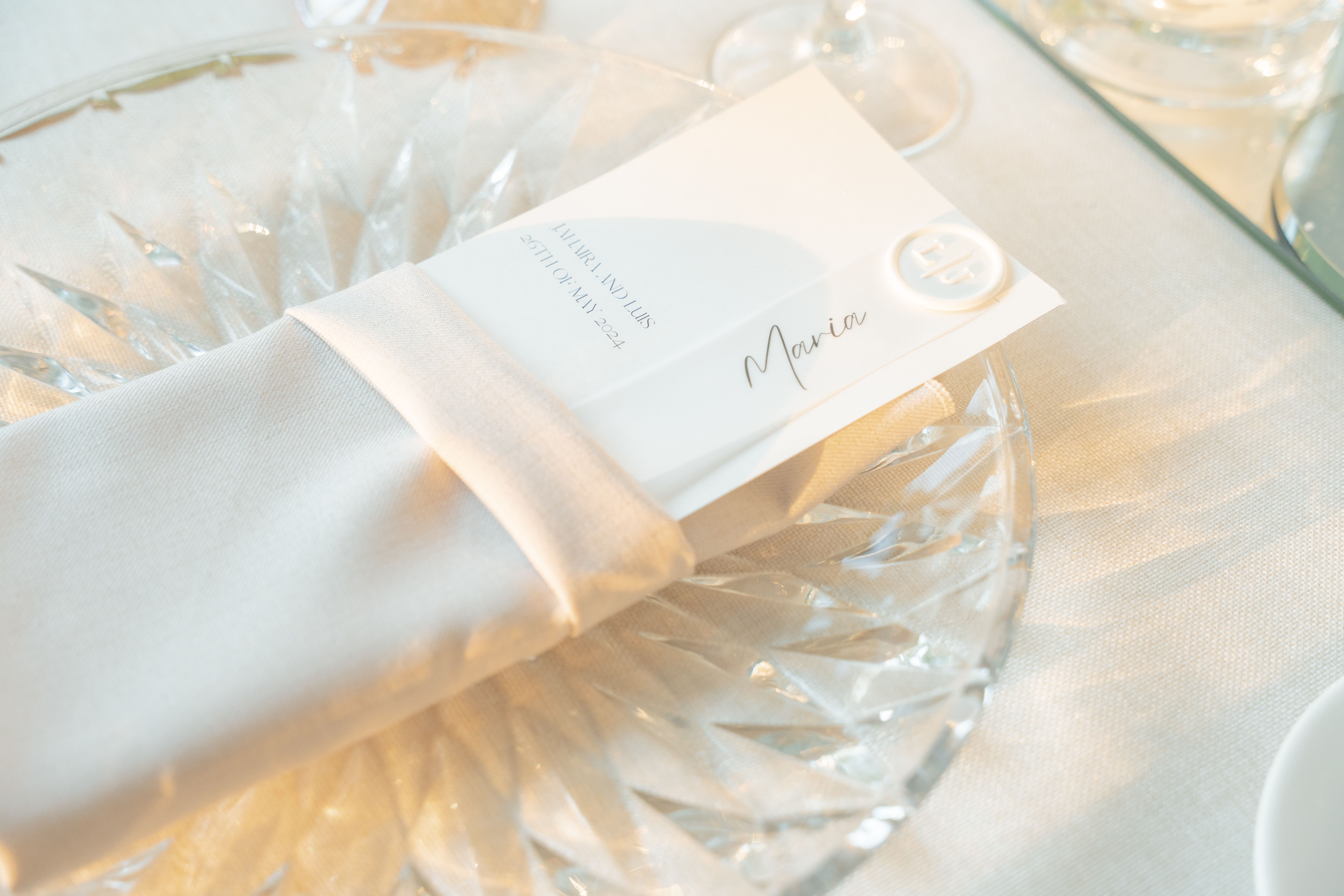 A sophisticated table setting with a menu card elegantly placed in a white napkin.