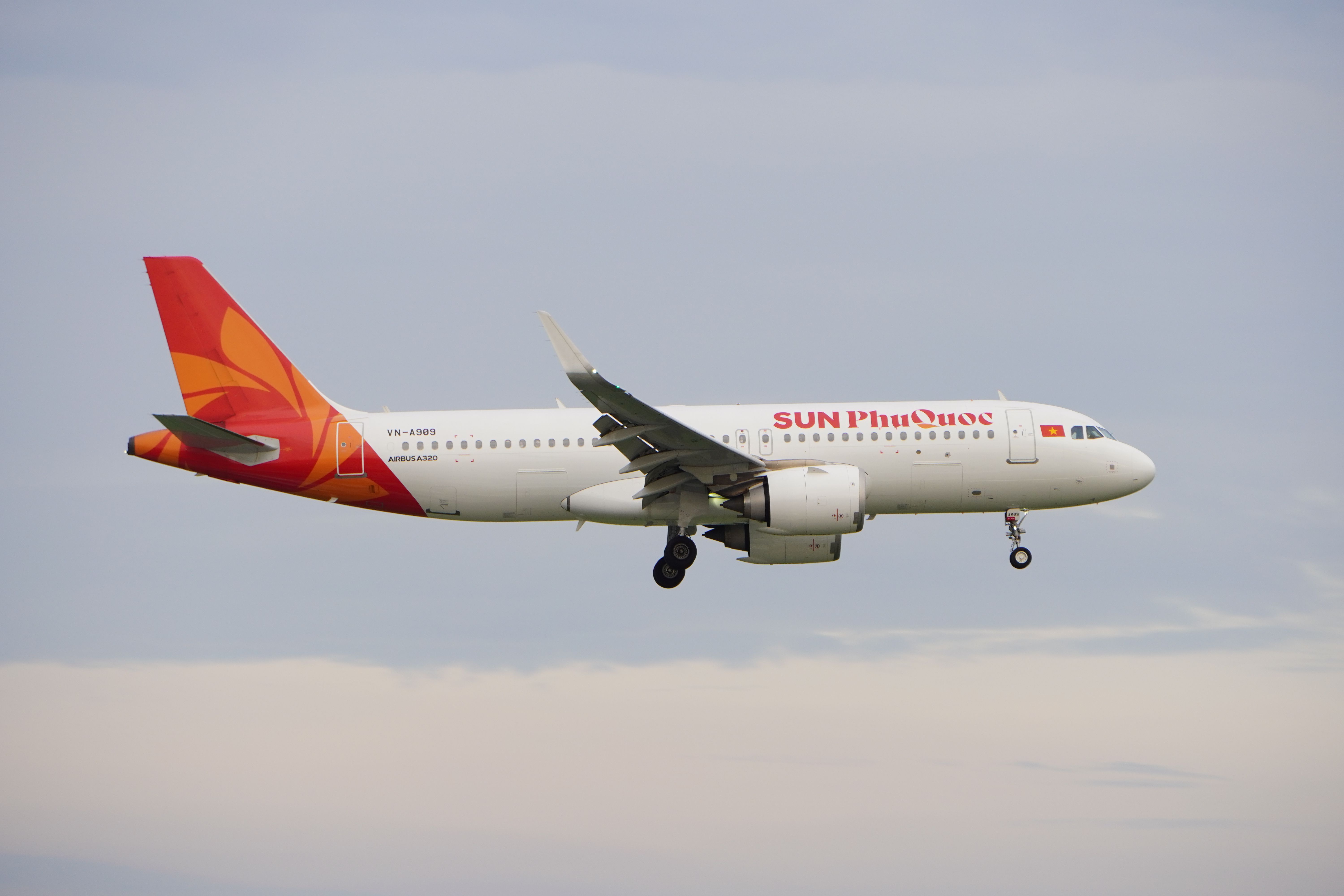 Airbus A320 in Sun Phu Quoc livery captured mid-flight against a clear sky.