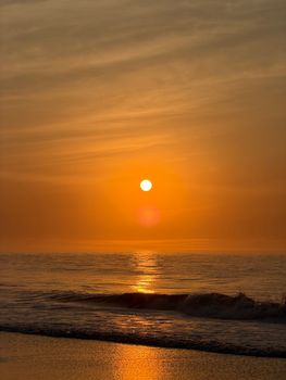 A serene sunrise at Ocean City beach with golden reflections on the waves.