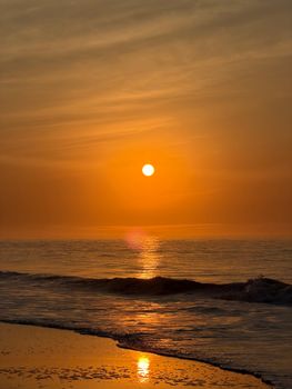 Serene sunset over Ocean City beach with calm waves and vibrant sky.