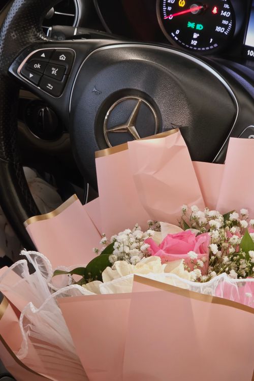 Free A beautiful bouquet of pink and white flowers inside a luxury car, emphasizing elegance and sophistication. Stock Photo