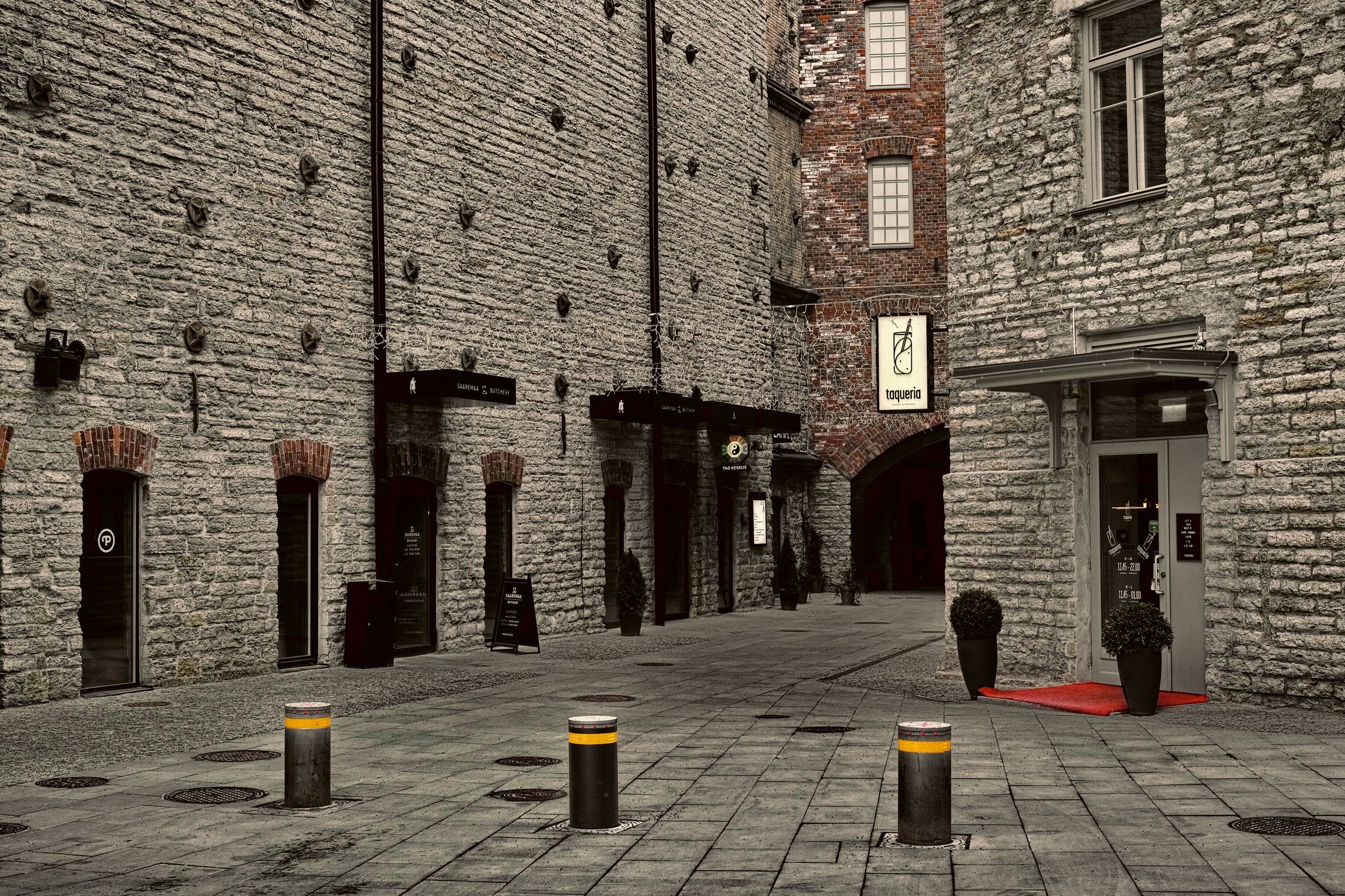 Explore a quiet cobblestone alley lined with historic stone buildings and charming boutique shops.