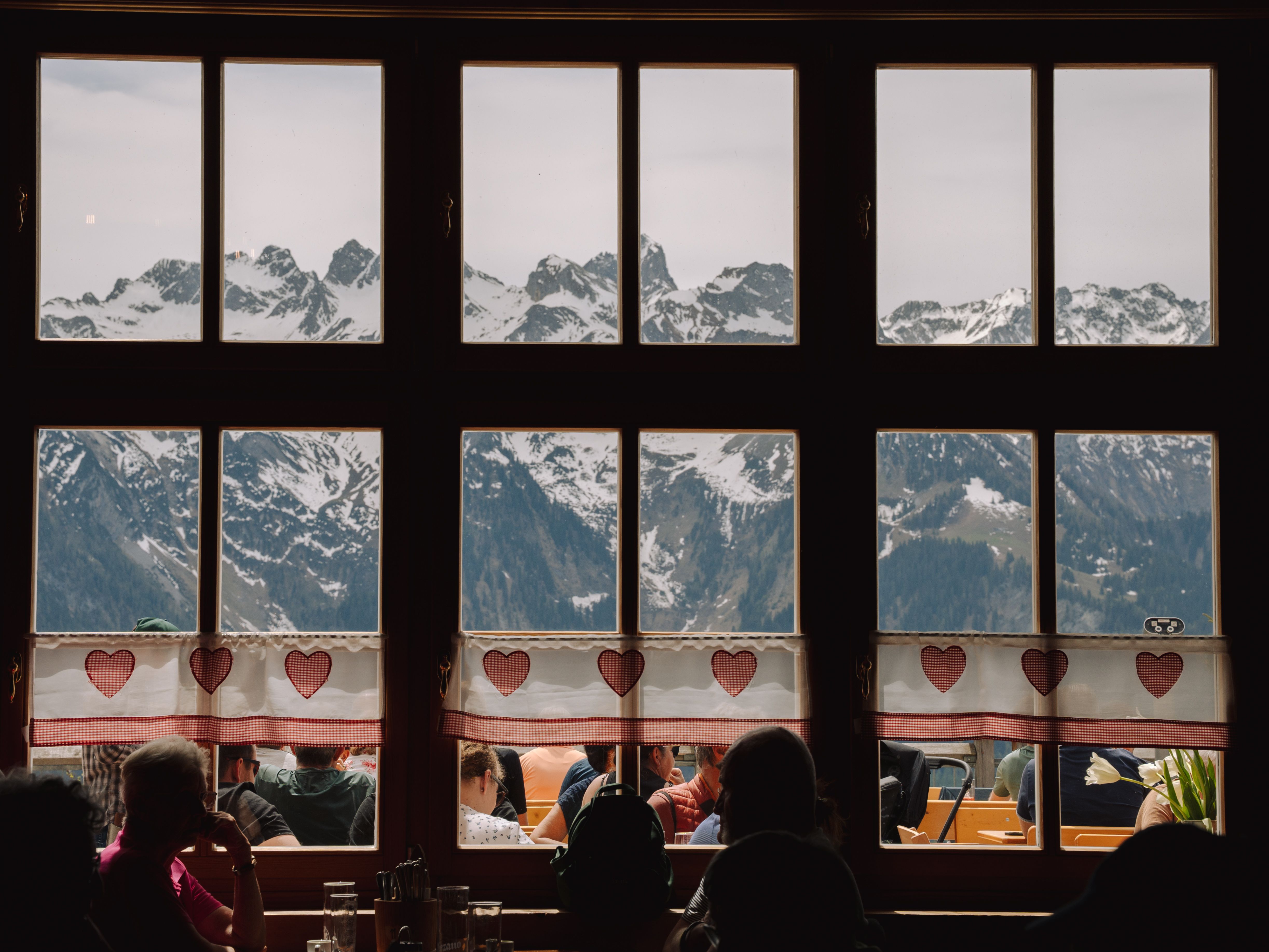 Cozy cafe view of snow-capped mountains through a window in Bludenz, Austria.
