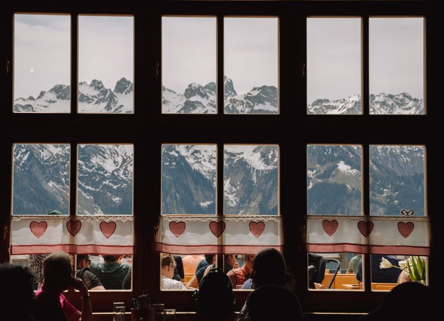 Cozy cafe view of snow-capped mountains through a window in Bludenz, Austria.