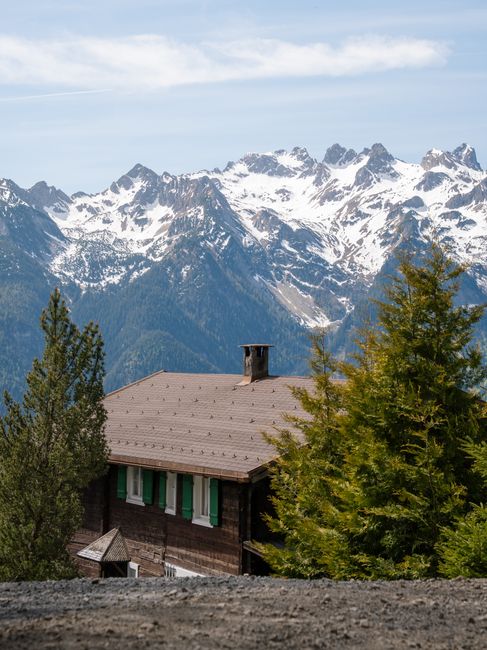 Wooden cabin nestled in the Austrian Alps, offering breathtaking views of snow-capped mountains.
