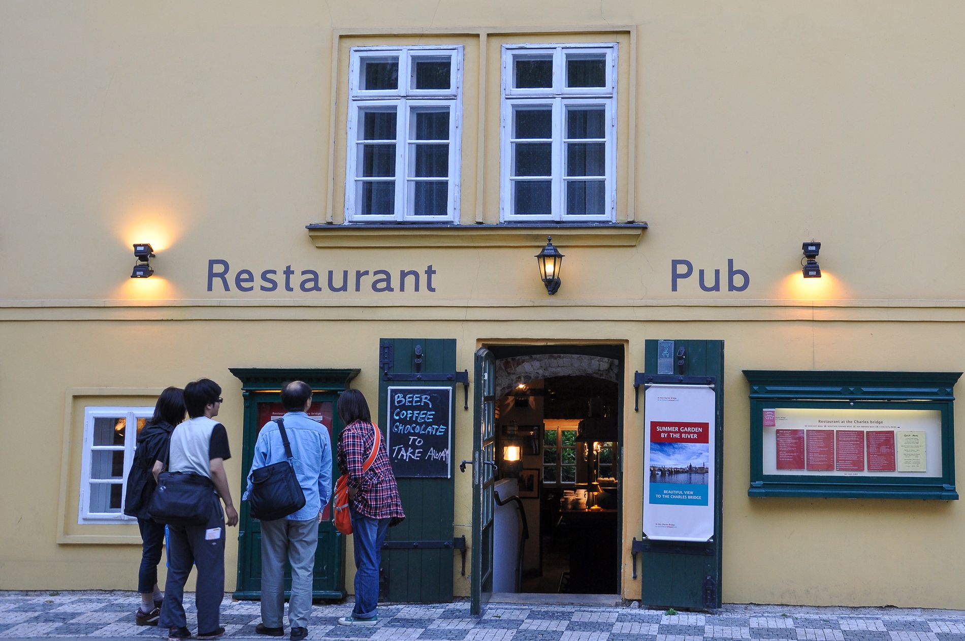 Historic Prague pub entrance with guests outside