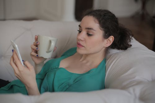 Free Woman In Teal Tank Top Holding White Ceramic Mug Stock Photo