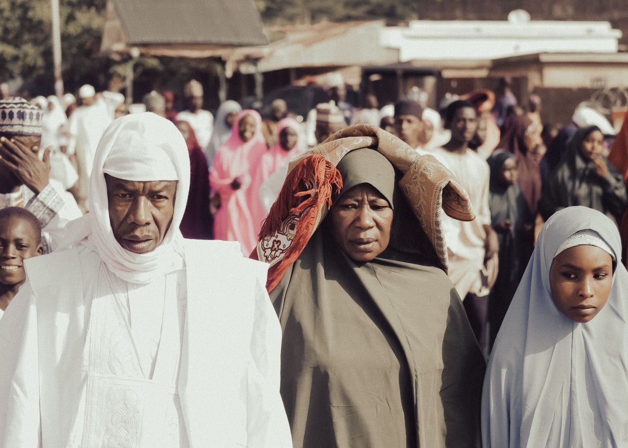 a diverse group of people in traditional garments during a day event i