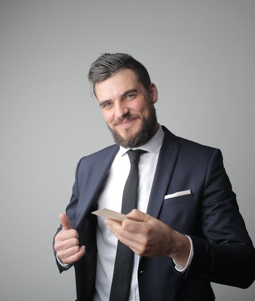Free Man in Black Suit Holding a Calling Card Stock Photo