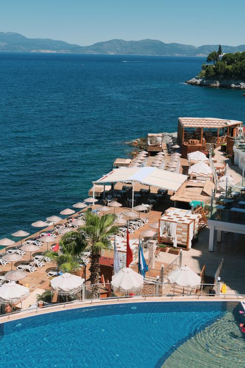Free Beautiful coastal resort featuring luxurious seating and infinity pool overlooking the sea. Stock Photo