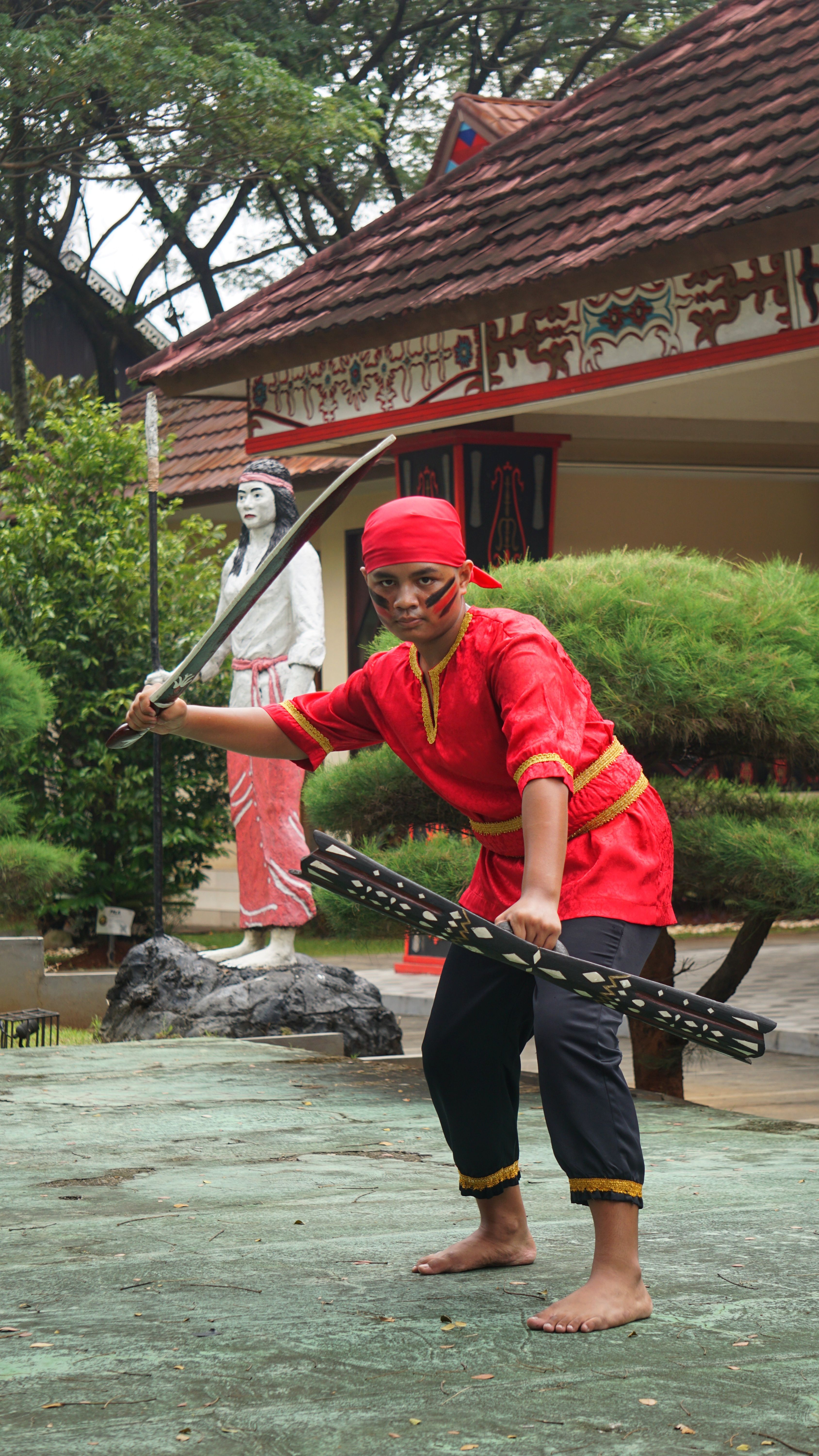 A traditional martial artist in vibrant attire performs in Jakarta, Indonesia.