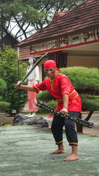 A traditional martial artist in vibrant attire performs in Jakarta, Indonesia. - Fotografer Sidoarjo