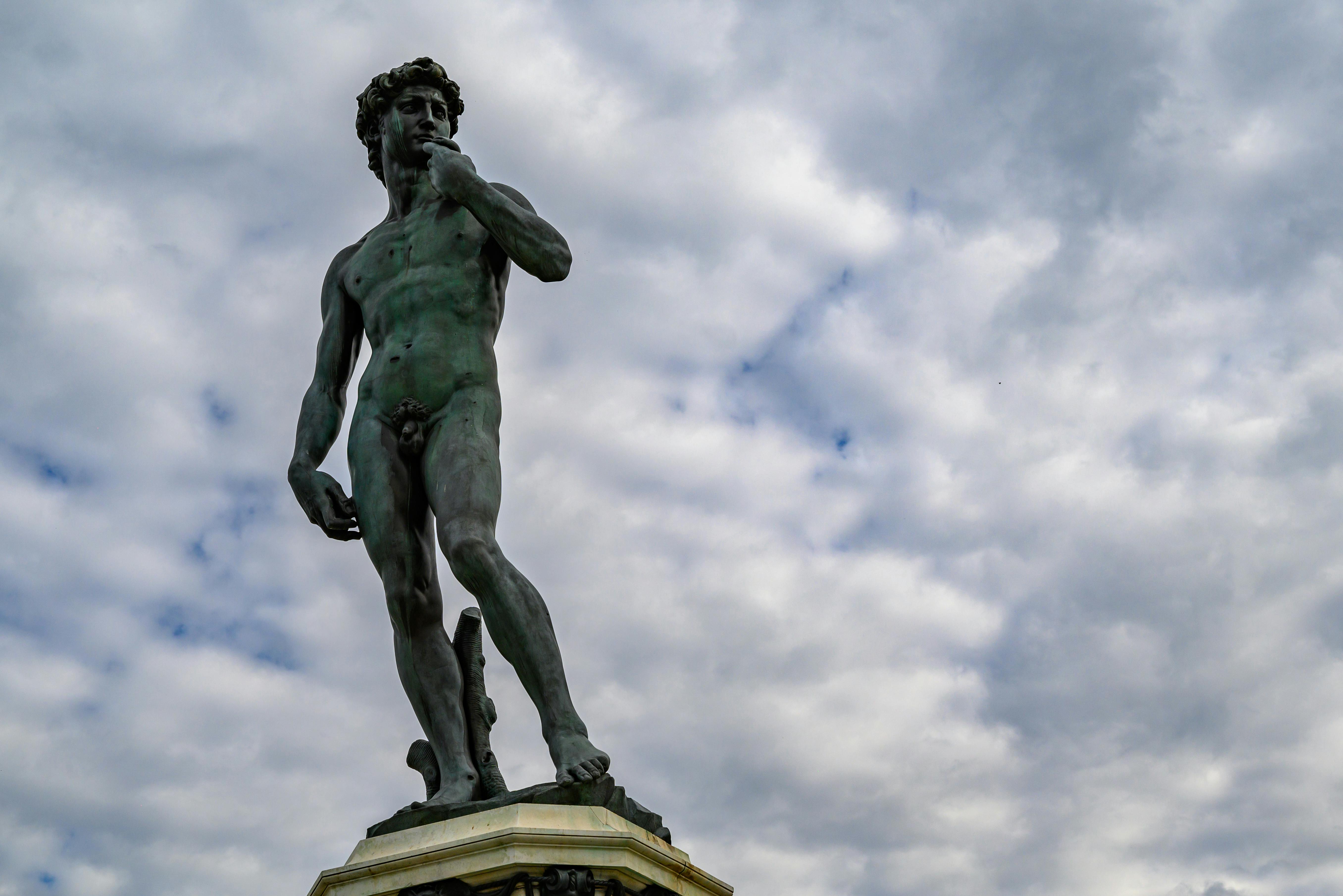 View of Michelangelo's David statue in Florencia, Tuscany against a dramatic cloudy sky.