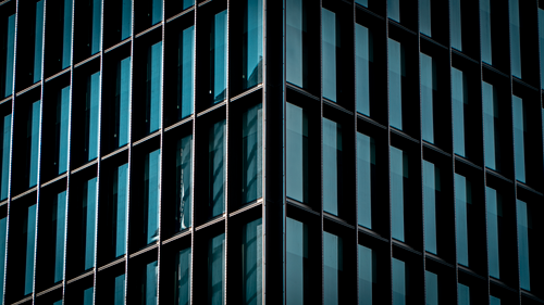 Free Close-up view of a modern office building facade with reflective glass windows. Stock Photo