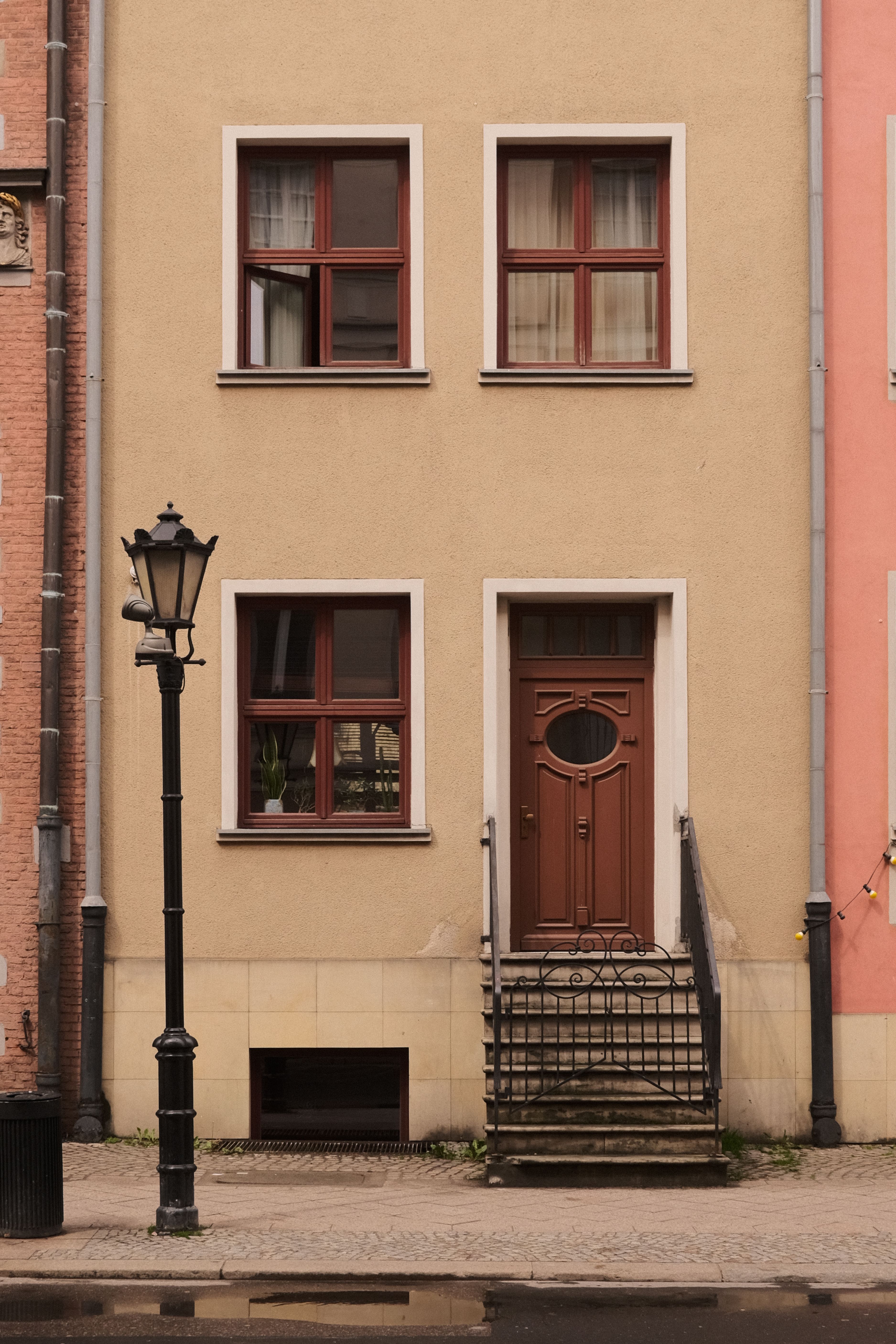 A detailed view of traditional architecture in Gdańsk's historic center with a classic facade and street lamp.