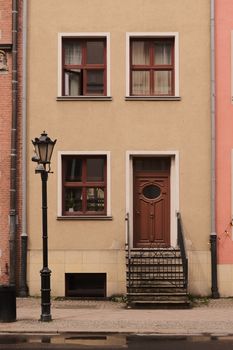 A detailed view of traditional architecture in Gdańsk's historic center with a classic facade and street lamp.