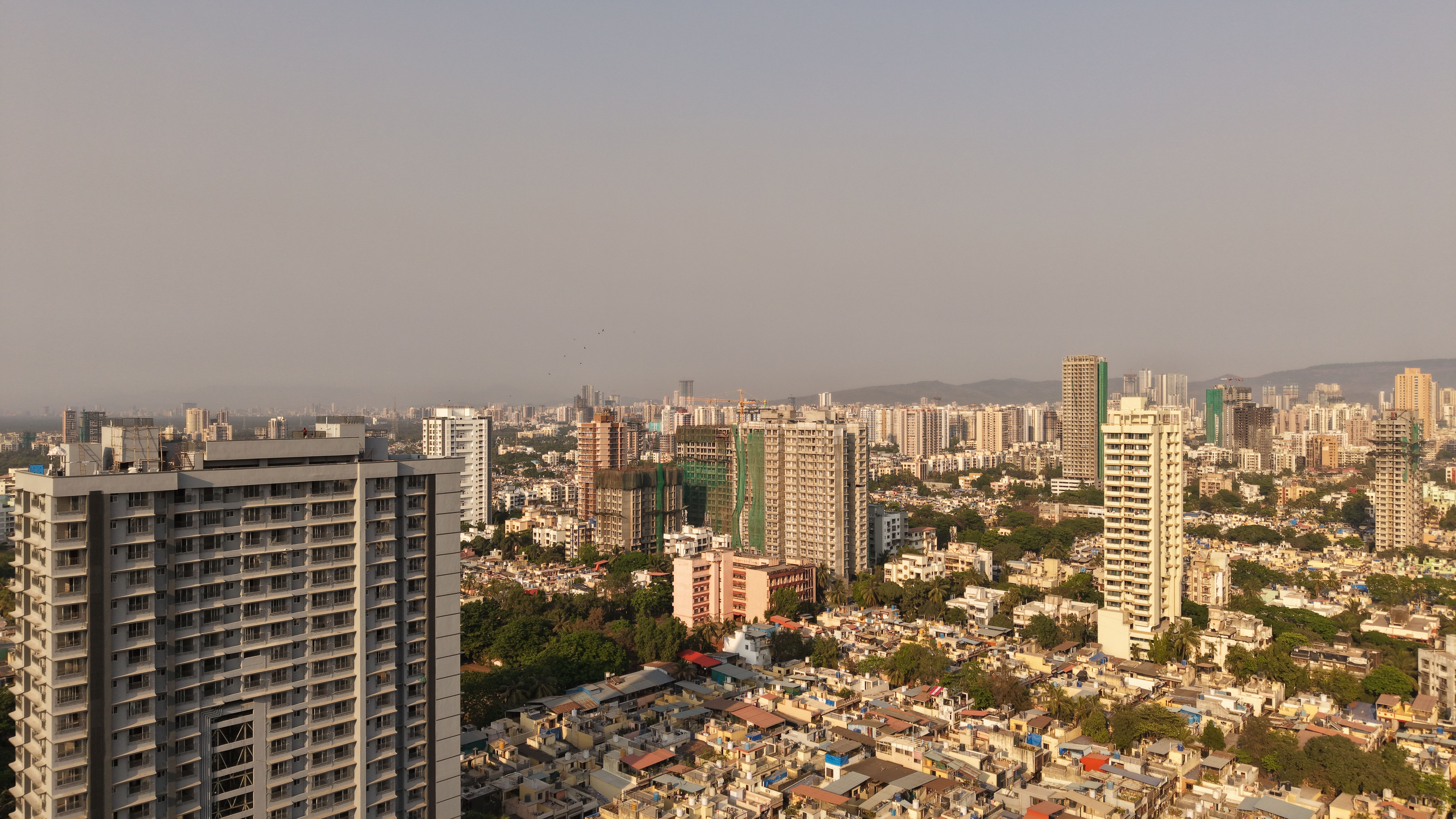 A wide aerial view of the Mumbai skyline showcasing urban architecture and city development during the day.