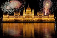 充满活力的烟花照亮了多瑙河上倒映的布达佩斯匈牙利议会大厦