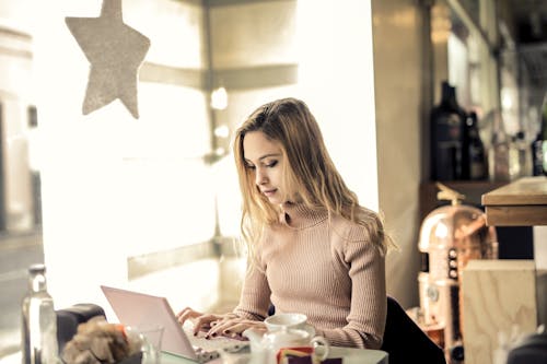 Woman in Pink Long Sleeve Shirt Using Laptop